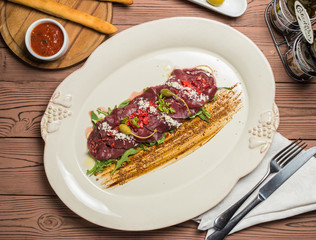 carpaccio with deer served on white plate