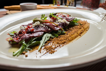 carpaccio with deer served on white plate