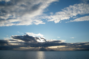 Yellow Sunbeams Through the Clouds on a Calm Ocean