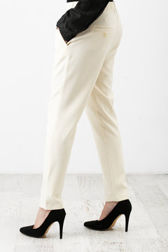 Young beautiful woman in a white pants and black shoes