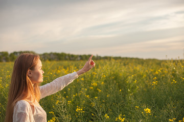 girl on the nature points the finger forward.