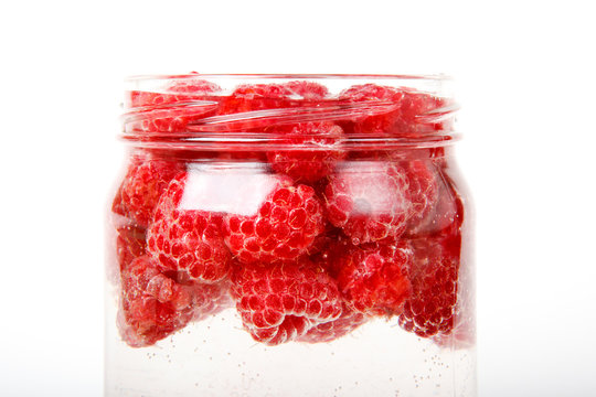 Raspberries in a jar of water isolated