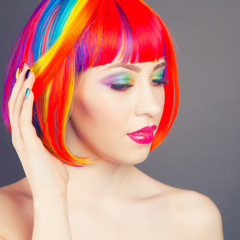 Fototapeta premium beautiful woman wearing colorful wig and showing colorful nails