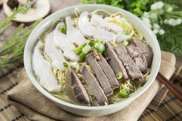 Chinese bowl of wanton noodle with beef anf pork on the table in restaurant