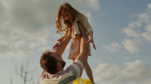 Father throwing daughter in air. slow motion
