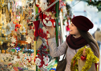 Girl choosing Christmas decoration at market.