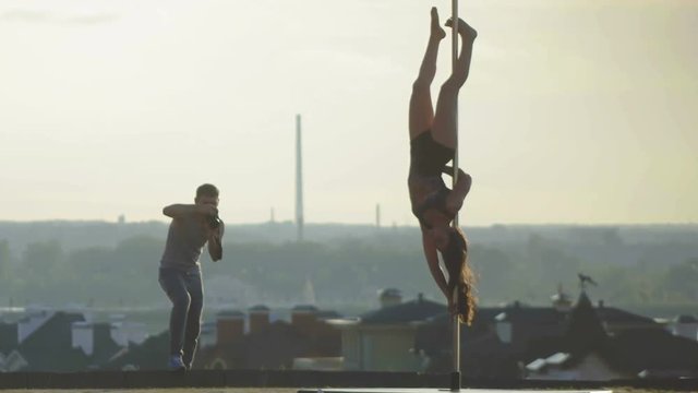Sport sexy attractive girl model posing on pole on center of city for photographer