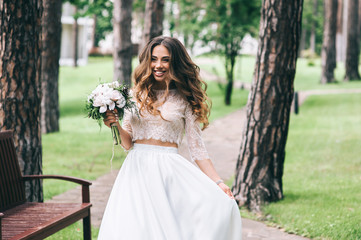 beautiful bride with white bouquet in park