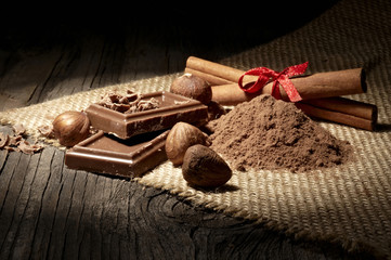 Chocolate with nuts on wooden background on linen