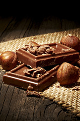Chocolate with nuts on the wooden background