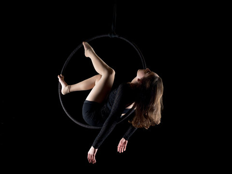 Graceful aerial dancer woman isolated on black