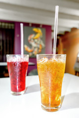 Lemon tea Thai herbal drinks with ice in glasses on the blurred cafe background.
