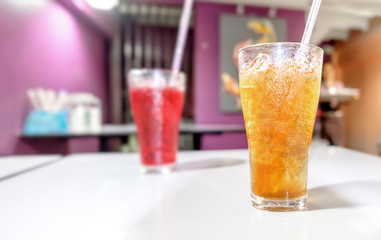 Lemon tea Thai herbal drinks with ice in glasses on the blurred cafe background.