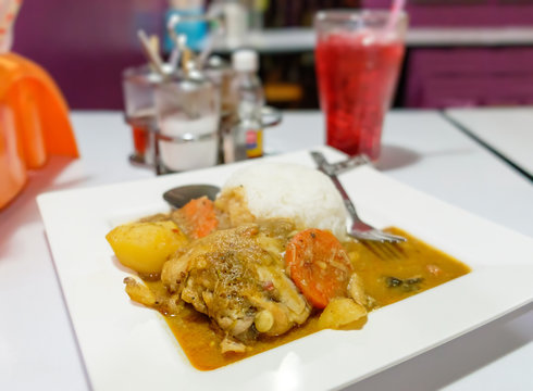 Thai cuisine, chicken curry with rice on the blurred cafe background.