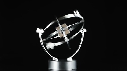 Close up of Newton's Cradle, Desk toy pendulum being activated, black background