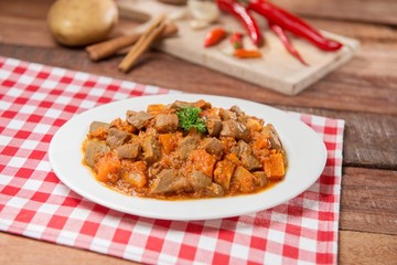 Plate of fried cube beef and pumpkin on the table in restaurant