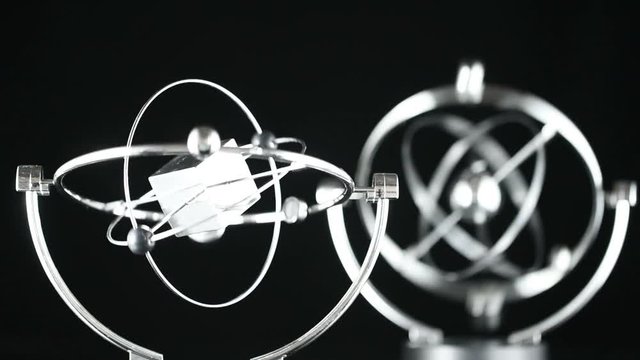Close up of Newton's Cradle, Desk toy pendulum being activated, black background