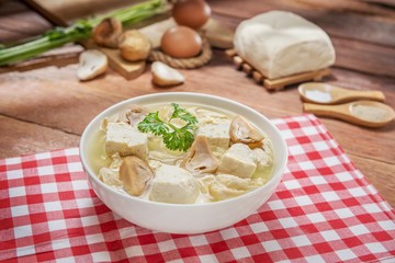 Bowl of tofu soup with mushroom on the table in restaurant