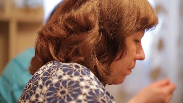 Middle-aged woman drinking tea at home