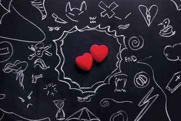 Two hearts surrounded by troubles and problems. Love will find a way! Hand drawing on a black board.