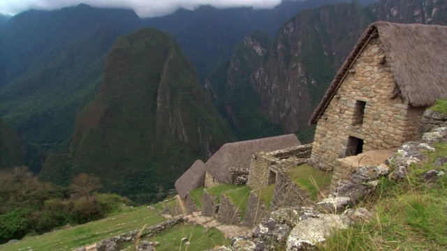 Machu Picchu, Peru: Pan from thatched roofs to Eastern Urban Center