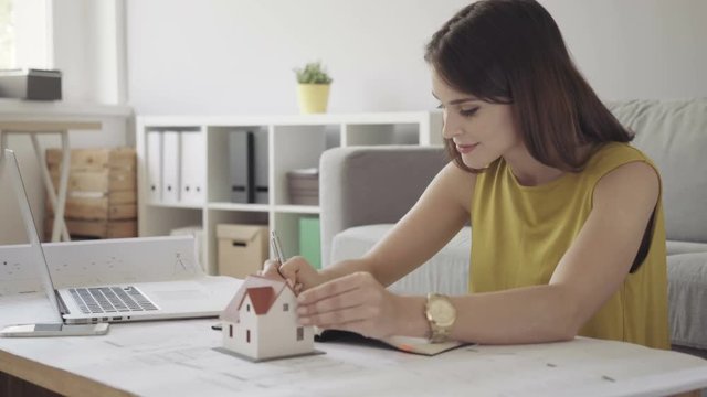 Female architect working from home over some bluerprints