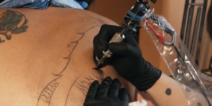 Tattoo being drawn on a woman's shoulder