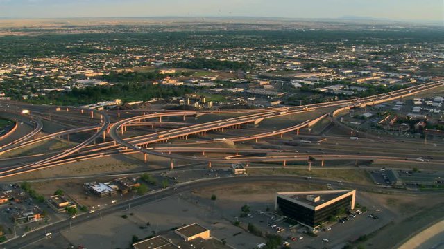 Orbiting Albuquerque freeway interchanges with wide view of plains beyond. Shot in 2008.