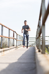 Full length portrait of handsome runner jogging fast down the br