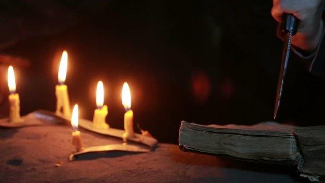 witch holding the magic ritual. old book and candle. halloween