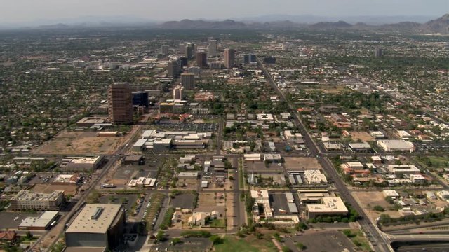 High aerial approach to Phoenix skyscrapers with mountains in background. Shot in 2008.