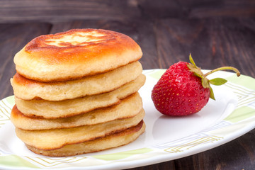 fritters on a plate with strawberries isolated white background