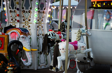 Fototapeta na wymiar Carousel for children white Horse closeup in the amusement park