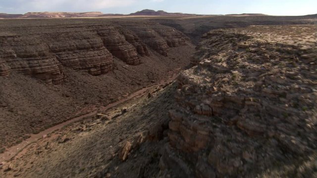 Flight over dry watercourse in rough, arid terrain