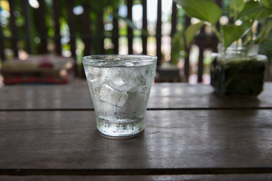 Cold water in a glass on a wooden table. 