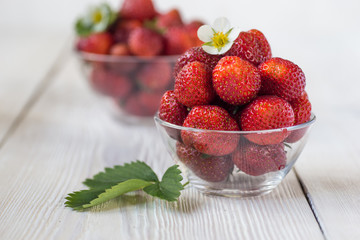 Appetizing strawberry in the bowl. White rustic table