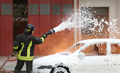 firefighters during exercise to extinguish a fire in a car