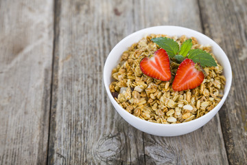 Granola with strawberries on a wooden table