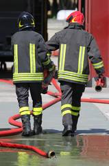firefighters carry the hydrant and hose pipes after put off the