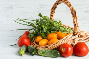  Fresh vegetables.   Fresh vegetables in a wicker basket on a light wooden background.