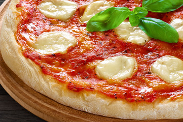 Pizza Margherita on dark wooden background