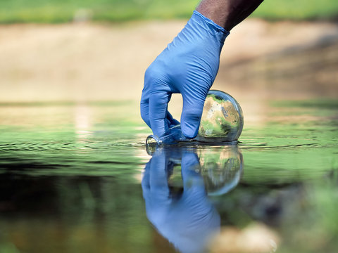 Water Sample. Hand In Glove Collects Water To Explore. Concept - Water Purity Analysis, Environment, Ecology. Water Testing For Infections, Permission To Swim 