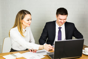 Business people discussing ideas at meeting using laptop in the office.