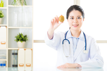 Young asian nutritionist holding a kiwi