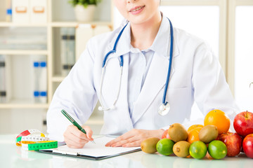 Young asian nutritionist doctor writing diet plan