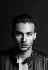 Sexy and expressive shirtless male model flirting against black background