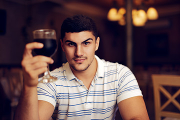 Handsome Man Raising Wine Glass in Toast