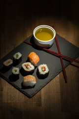 Sushi Set sashimi and sushi rolls served on stone slate