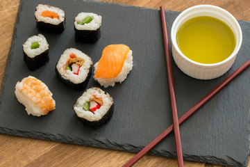 Sushi Set sashimi and sushi rolls served on stone slate