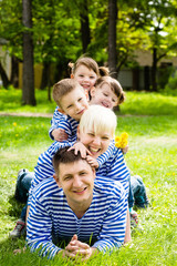 Happy family: mother, father, son and daughters-twins in the park on a sunny summer day